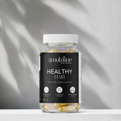 A clear jar labeled Healthy Hair contains yellow and white capsules. The label highlights benefits such as reduced fall, enhanced shine, and scalp nourishment. The jar is placed on a white surface with a light background.