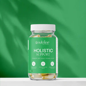 A clear jar labeled Holistic Support contains yellow and white capsules against a bright green background, with a label featuring benefits like stress relief, enhanced energy, immunity support, and Ashwagandha.